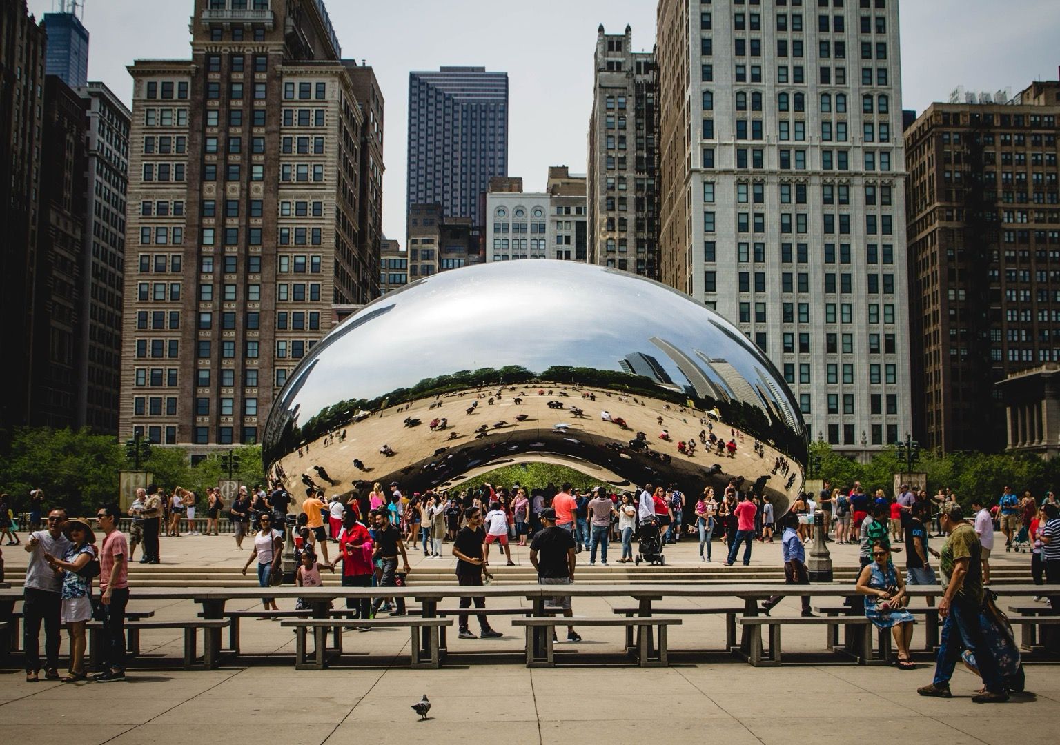 Cloud Gate in Chicago's Millennium Park, reflecting the skyline and the crowd beneath it